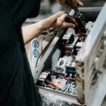 Technician adjusting wires in an electrical control panel for maintenance